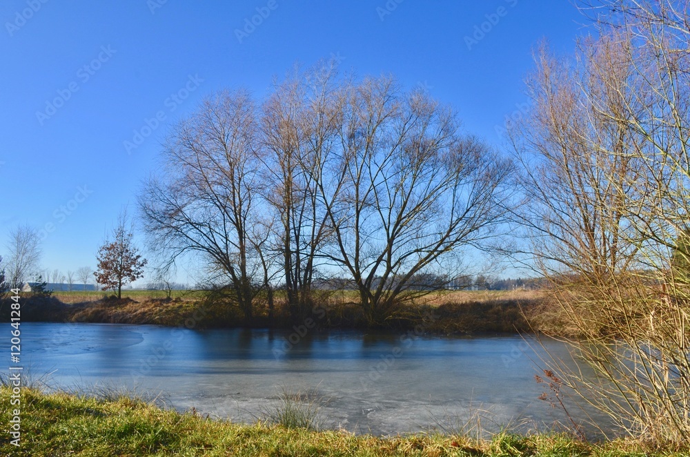 landscape of a winter frozen lake, the surface of the lake is covered with ice, blue sky, sunny day landscape of a winter frozen lake, the surface of the lake is covered with ice, blue sky, sunny day