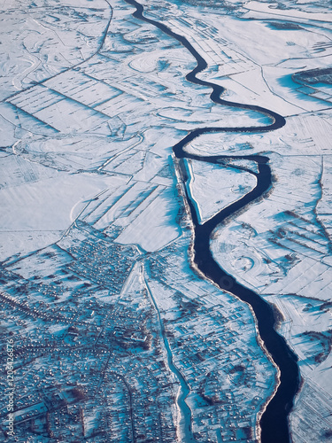 An aerial shot of the snowy landscape below. Flying above Russia in the winters.
