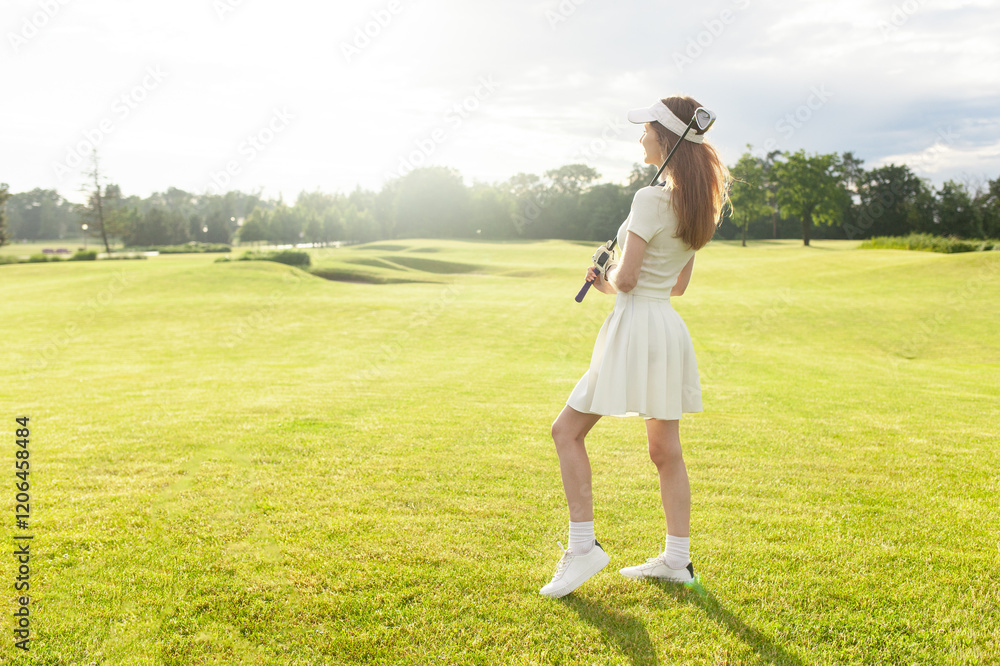 young attractive girl in sports uniform plays golf on field with lawn at sunset, woman with golf club plays sports outdoors in nature young attractive girl in sports uniform plays golf on field with lawn at sunset, woman with golf club plays sports outdoors in nature