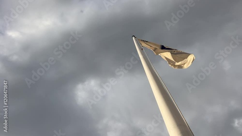 View of a flag fluttering in tatters. Daylight. Low angle. Static photo