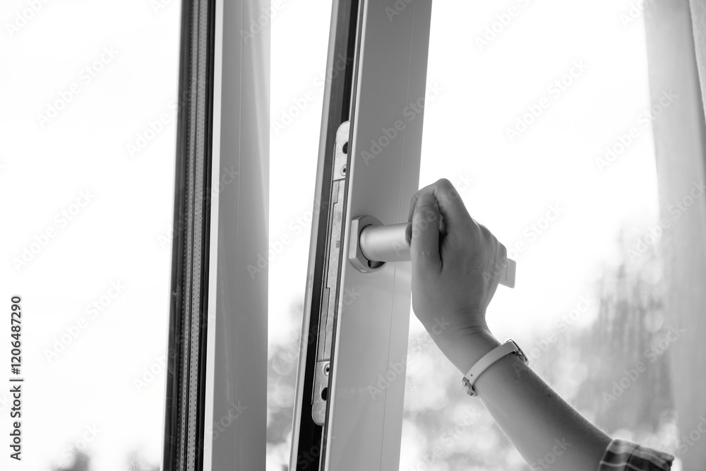 Side view - Monochrome close-up of a right hand operating a high-quality PVC window handle, showcasing ergonomic design and professional functionality. Side view - Monochrome close-up of a right hand operating a high-quality PVC window handle, showcasing ergonomic design and professional functionality.