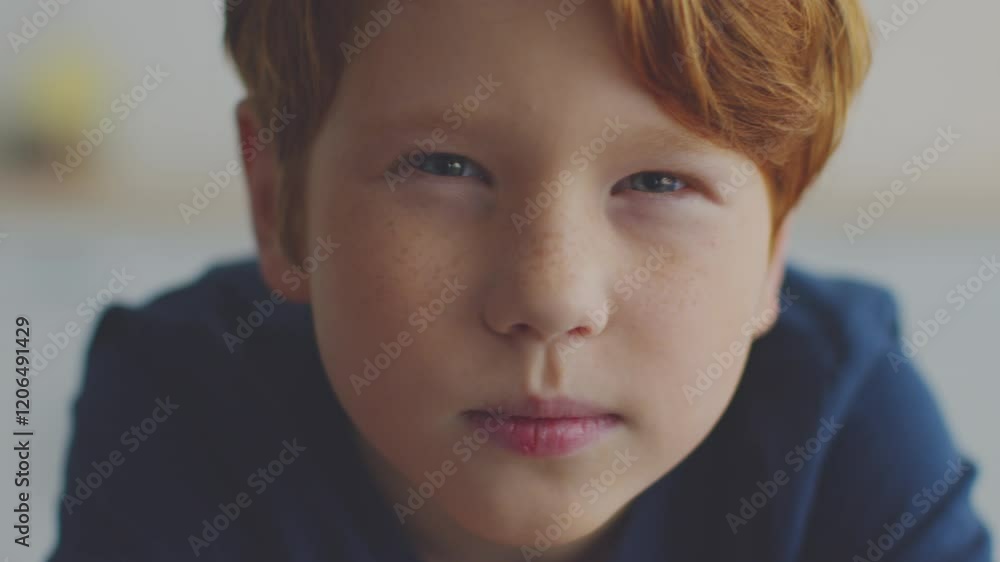 A preteen boy with ginger hair is focused on his online homeschooling lesson, studying intently while surrounded by a comfortable learning environment at home. A preteen boy with ginger hair is focused on his online homeschooling lesson, studying intently while surrounded by a comfortable learning environment at home.