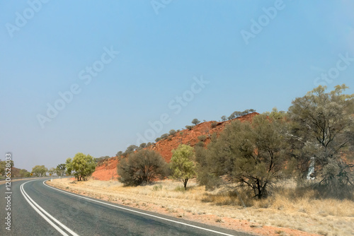 Bend in the road near Stuarts Well in the Northern Territory of Australia, showing dry outback landcape and flora.