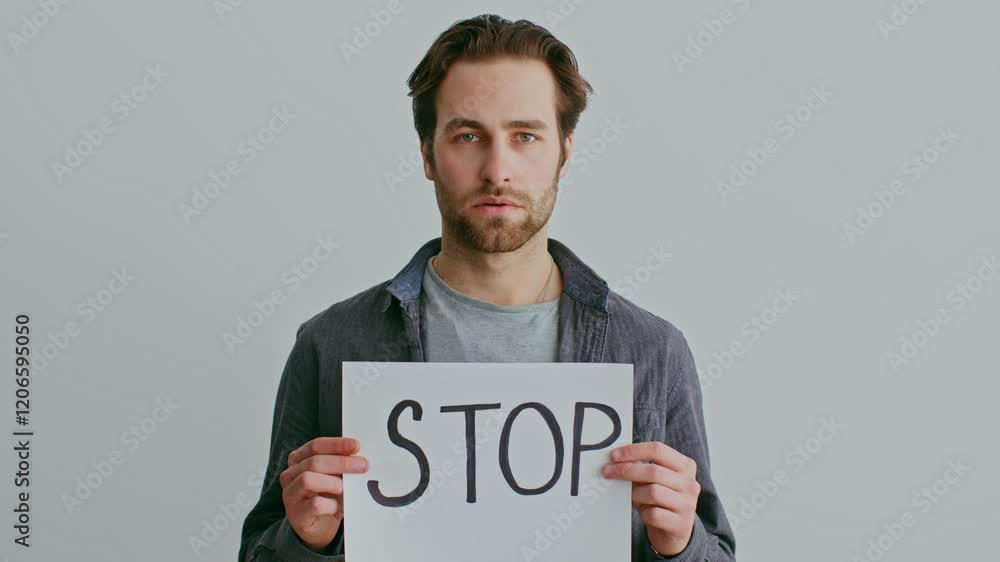 A man stands silently with closed eyes, reflecting a deep emotional struggle. The neutral backdrop highlights the atmosphere of tension often found in homes experiencing turmoil. A man stands silently with closed eyes, reflecting a deep emotional struggle. The neutral backdrop highlights the atmosphere of tension often found in homes experiencing turmoil.