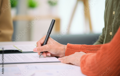 Fotografía Asian couple reviewing and sign contract financial documents with the guidance o