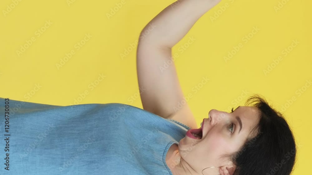 Vertical video. Cheer up. Unexpected gift. Sad woman receiving present in paper bag happy satisficed grateful facial expression isolated on yellow free space background. Vertical video. Cheer up. Unexpected gift. Sad woman receiving present in paper bag happy satisficed grateful facial expression isolated on yellow free space background.