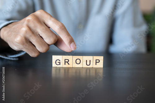 GROUP concept. Business man hand holding wooden cube words TEAM on a wood block