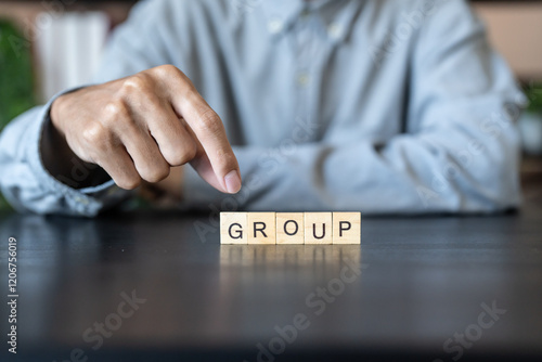 GROUP concept. Business man hand holding wooden cube words TEAM on a wood block