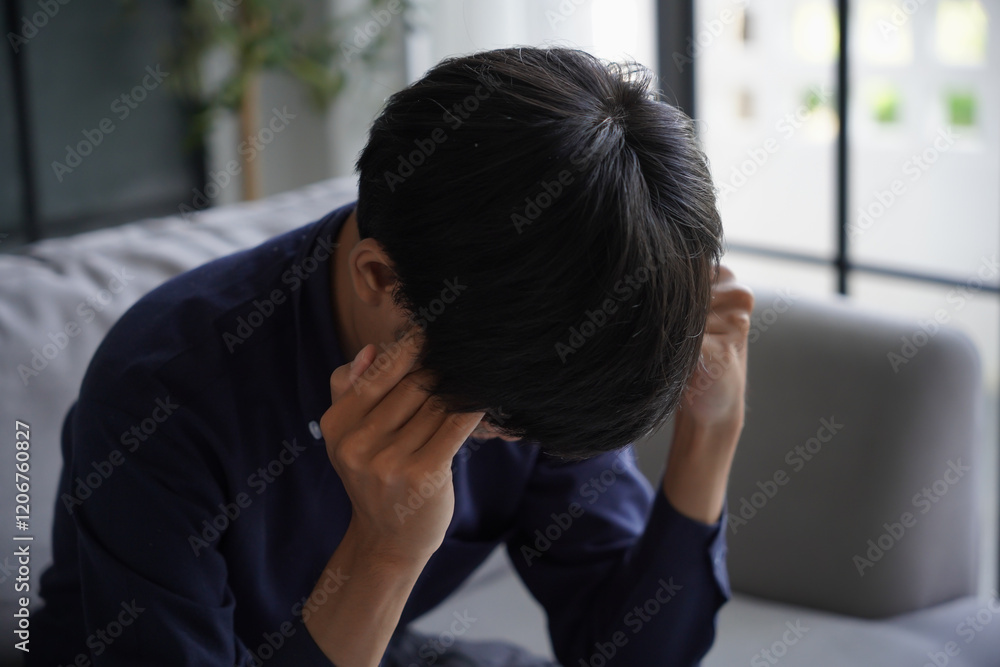 Stressed man is headache, He is sitting on sofa and massaging his head Stressed man is headache, He is sitting on sofa and massaging his head