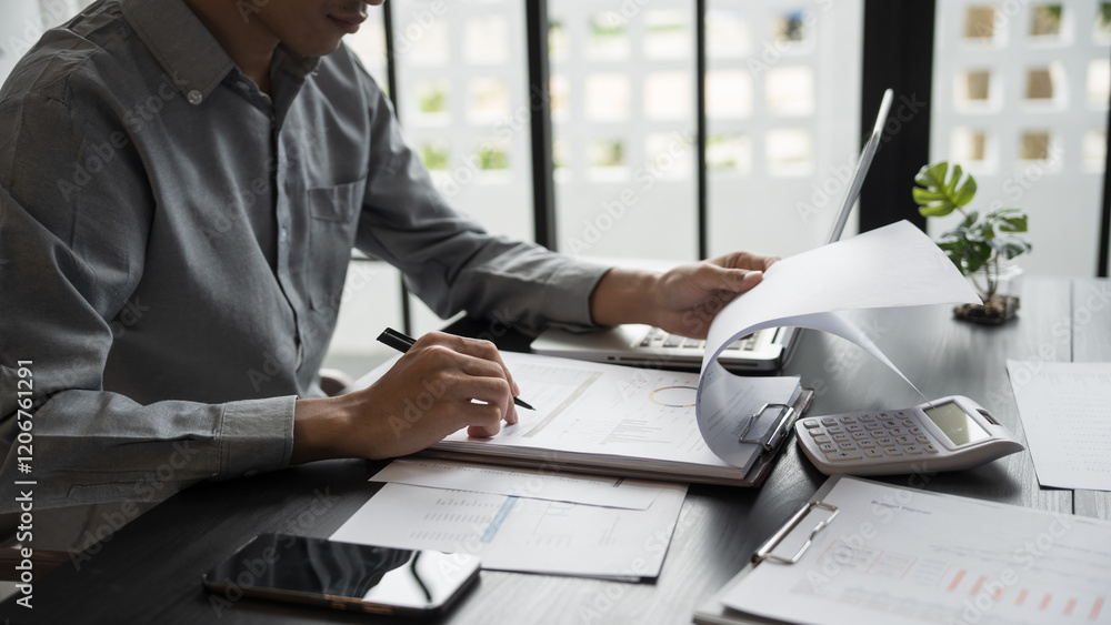 Φωτογραφία Asian business man holding paper document calculating tax insurance managing bud