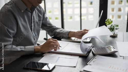 Asian business man holding paper document calculating tax insurance managing budget
