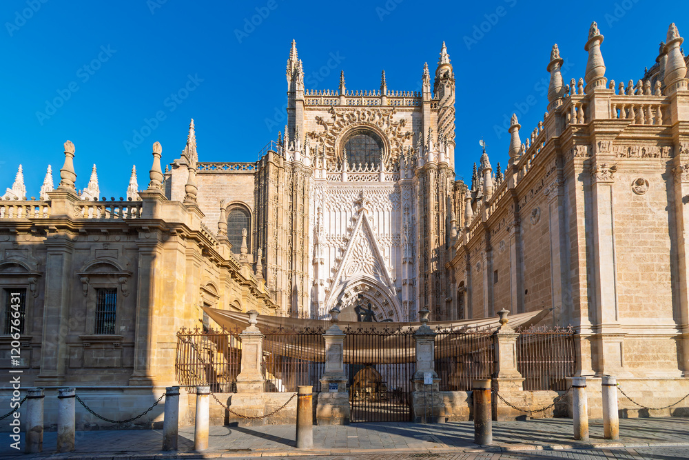 Fototapeta premium One of the entrances and small gated courtyard at the Seville Cathedral in the historic center of the Andalusian city of Seville, Spain.