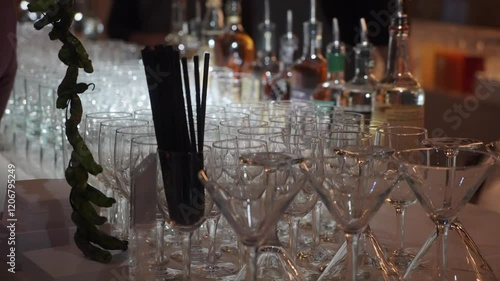 A beautifully pristine martini glass prominently stands out in the midst of an elegant row of exquisite glassware