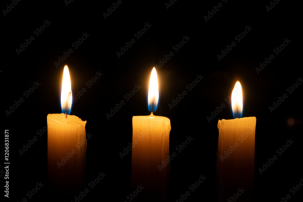 orange candle burns in the dark on a black background. The concept of memory and sorrow. orange candle burns in the dark on a black background. The concept of memory and sorrow.