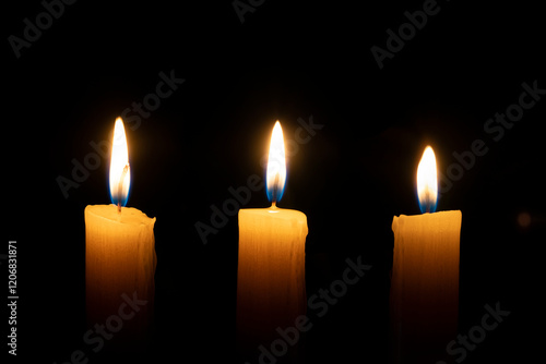 orange candle burns in the dark on a black background. The concept of memory and sorrow. photo