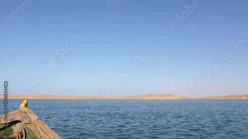 An old weathered fishing boot drives towards the sand dunes of Lac Naila. Where the Sahara desert meets the Atlantic Ocean, Lac Naila, National Park Kheniffis, Morocco. 4k natural landscape background