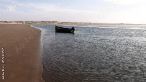 Old fishing boat is anchored at the sand dunes of Lac Naila, National Park Kheniffis, Morocco. 4k natural background footage. 
