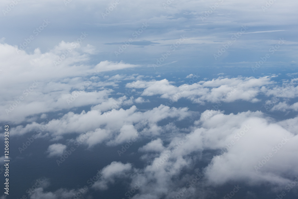 Fototapeta premium Cloudscape view from an airplane window on a sunny blue sky background. Skyline view, blue sky with clouds