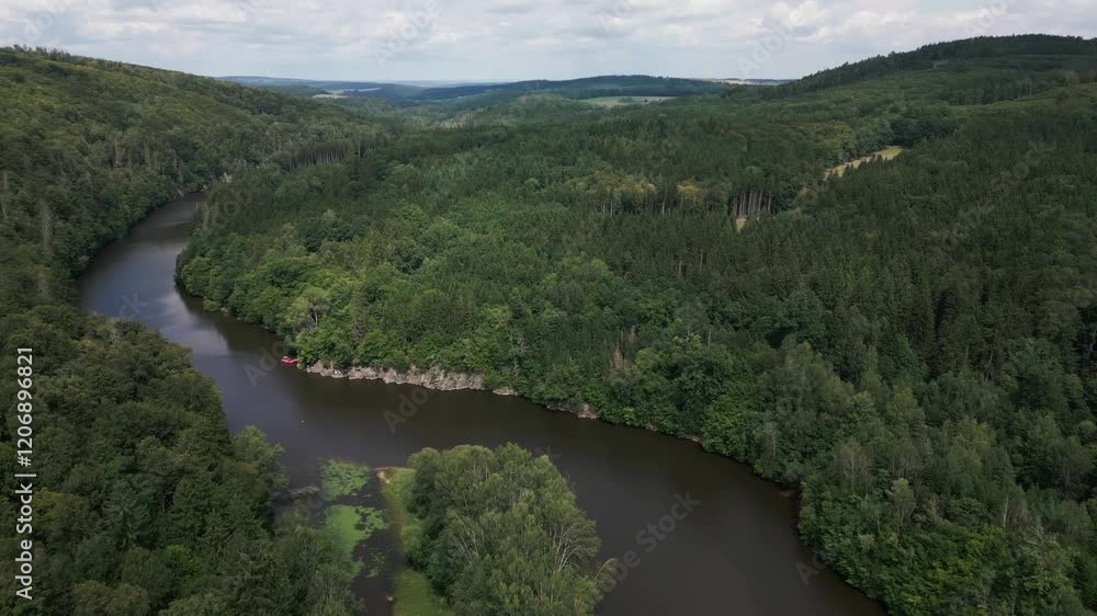 Drone follows river meandering watercourse through lush green valley landscape Drone follows river meandering watercourse through lush green valley landscape