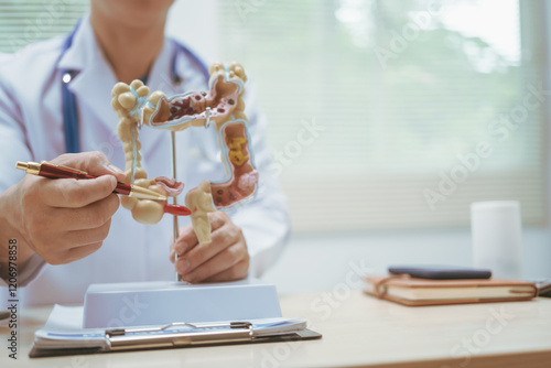 Male doctor treating intestinal diseases at a hospital table, discussing intestinal disease models, diagnosing gastritis ileitis,appendicitis, colon cancer,providing treatment plans and patient care photo