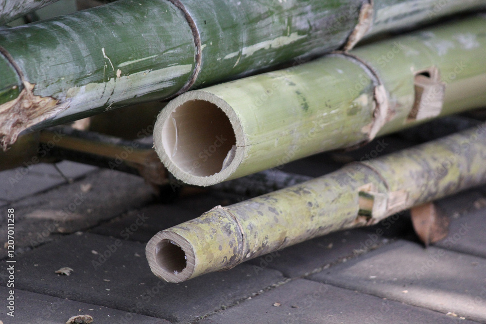 A close-up view of stacked bamboo poles, showcasing their natural texture and earthy tones. A close-up view of stacked bamboo poles, showcasing their natural texture and earthy tones.