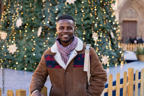 Young black man smiling in front of the Christmas tree in City Square. photo