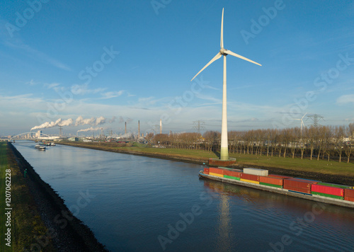 Cargo ship sailing near wind turbines at sea under blue sky photo