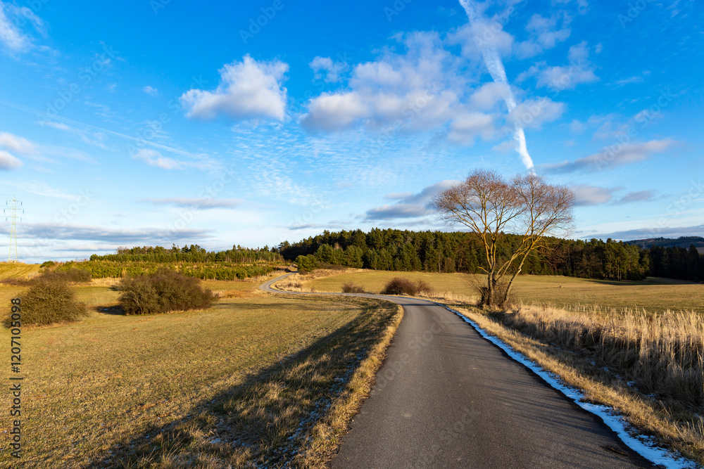 A paved road in the countryside. A cold, winter evening