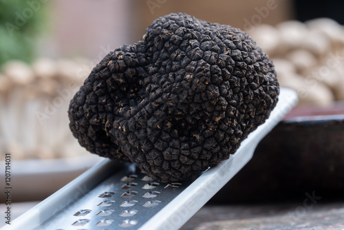 Delicious mushrooms, fresh black summer truffle mushroom and grater for making truffle dishes with tasty aroma photo