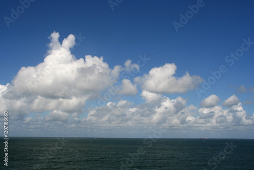 Seascape with white clouds in a blue sky and the North Sea on the coast of The Netherlands photo