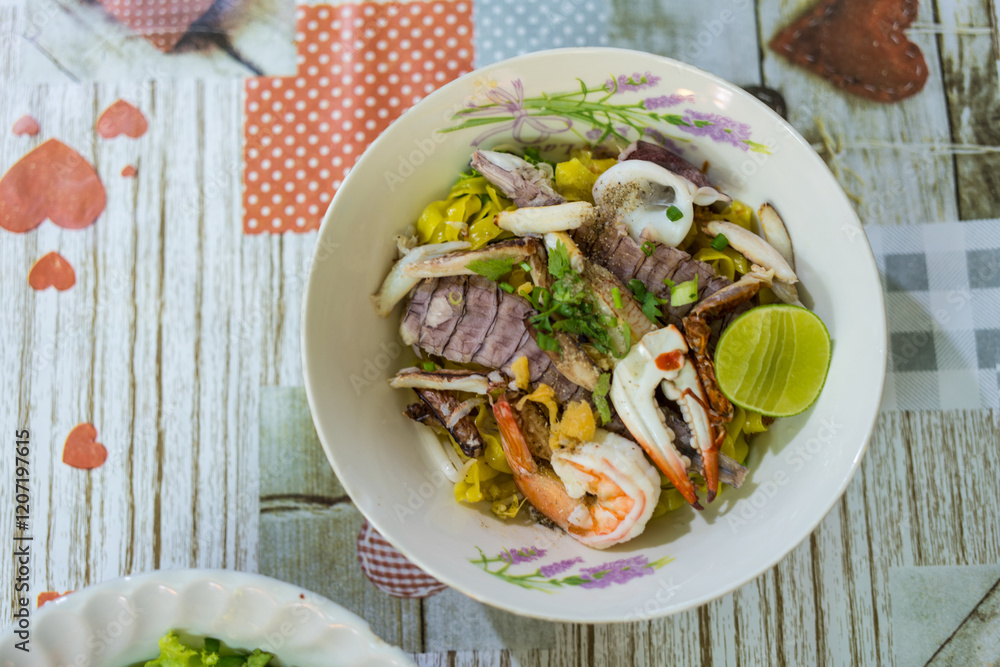 Fototapeta premium A bowl of special food of dry egg yellow noodle with crawfish, shrimp and crab, sold in Chanthaburi province, Thailand