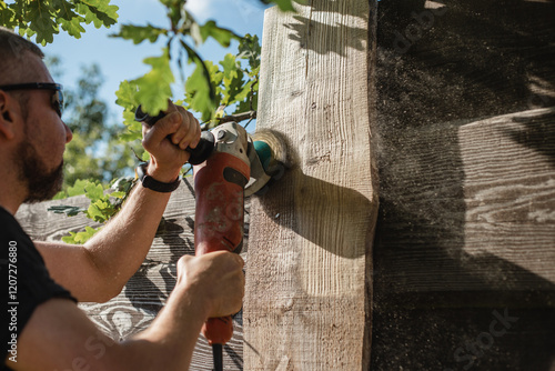 Rough cleaning and blanching of old boards - renovation of garden fence slats - rough male labor photo