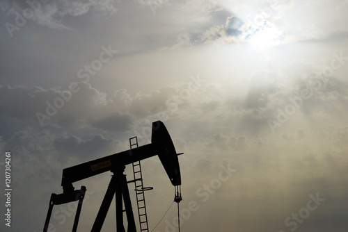 Pumpjack aka oil horse, nodding donkey, oil jack, beam pump raises crude oil in the Bahrain desert at Sakhir on the Persian Gulf