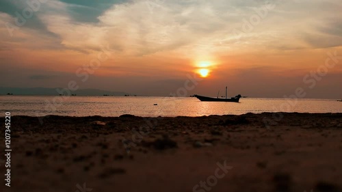 Silhouetted Boat at Sunset Over Calm Sea with Scenic Horizon