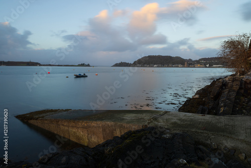 Looking across Oban Bay with Oban in the distance and a concrete jetty in the foreground. Argyll and Bute, Scotland, UK. photo