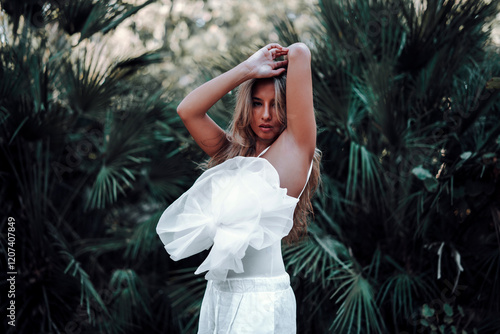 Obraz na płótnie Chica rubia joven posando frente a cámara en jardin urbano w salonie