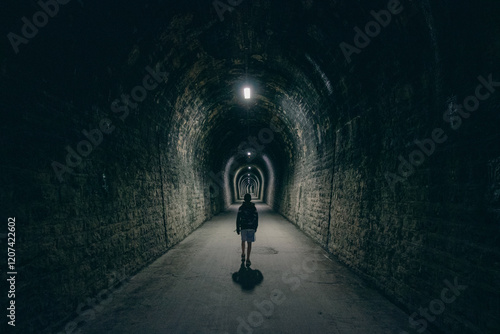 silhouette dans un long couloir, tunnel sombre et obscur photo