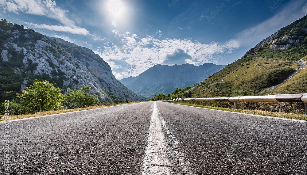Naklejka premium Curved Road Through the Mountains with Clear Sky on a Sunny Day