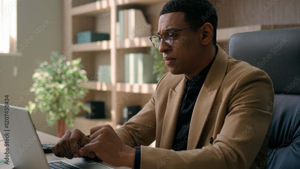 Fototapeta premium Focused African American man businessman working with corporate documents sales research professional employer office manager business CEO chief typing data on laptop computer analytics commerce work