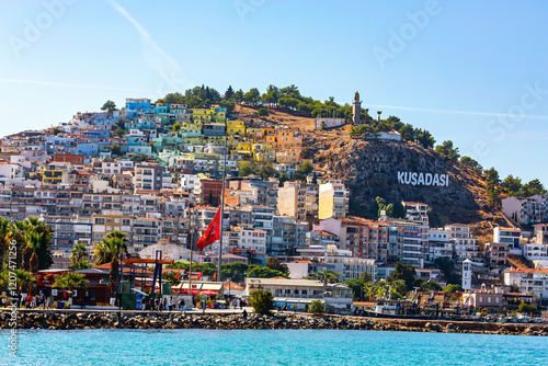 Scenic view of colorful hillside houses on Kese Dagi hill in Kusadasi, with the iconic sign and Mustafa Kemal statue under a clear sky. Kusadasi, Aydin, Turkey (Turkiye). photo