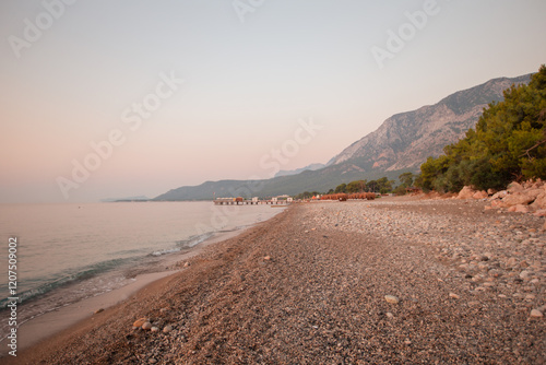 Fototapeta Naklejka Na Ścianę i Meble -  Calm morning landscape of pebble sand beach sea and mountains.