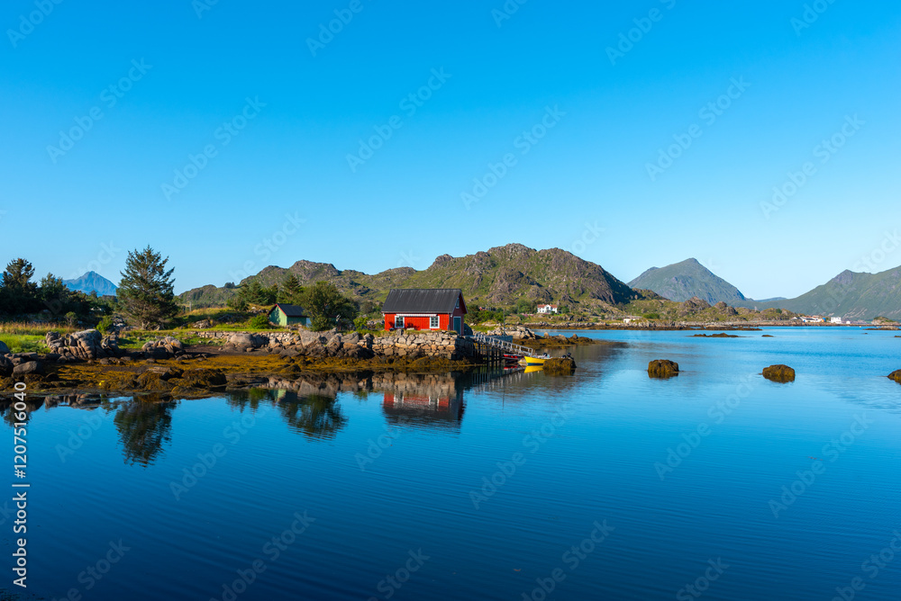 Obraz premium View over the landscape of the bay Skotnesosen with a traditional red fisherman's house. Ballstad in the Lofoten district in Norway