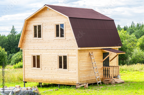 New small wooden house on a metal pile foundation in summer photo