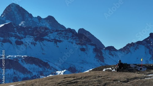 Helicopter on a snowy mountain helipad with a picturesque alpine backdrop. Helicopter, sightseeing flights over the Dolomites and Alps. Helicopter is standing on a landing field in the mountains. photo