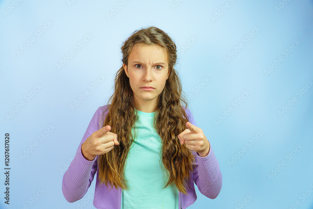 Fototapeta premium Dissatisfied angry little girl looking indignantly straight ahead