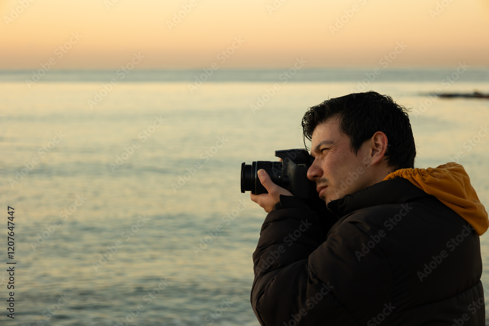 Close up of warmly dressed male photographer taking photos by the sea on a winter morning. Lifestyle Close up of warmly dressed male photographer taking photos by the sea on a winter morning. Lifestyle
