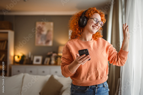 cheerful caucasian woman dance and listen to music on headphones photo