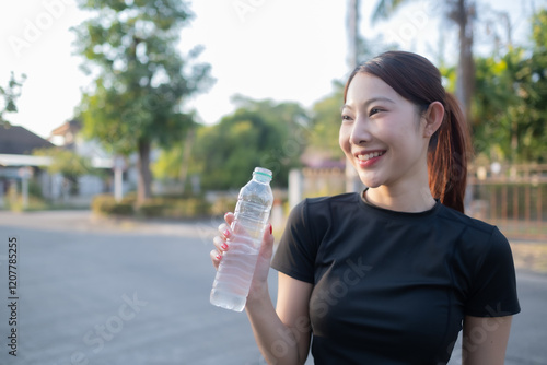A woman is holding a bottle of water