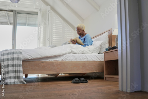 Woman writing in note pad in bed photo