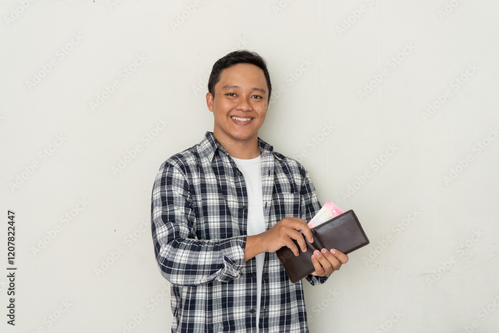 Young Asian man take out his money from the wallet with happy expression. Man smiling while holding his wallet Young Asian man take out his money from the wallet with happy expression. Man smiling while holding his wallet